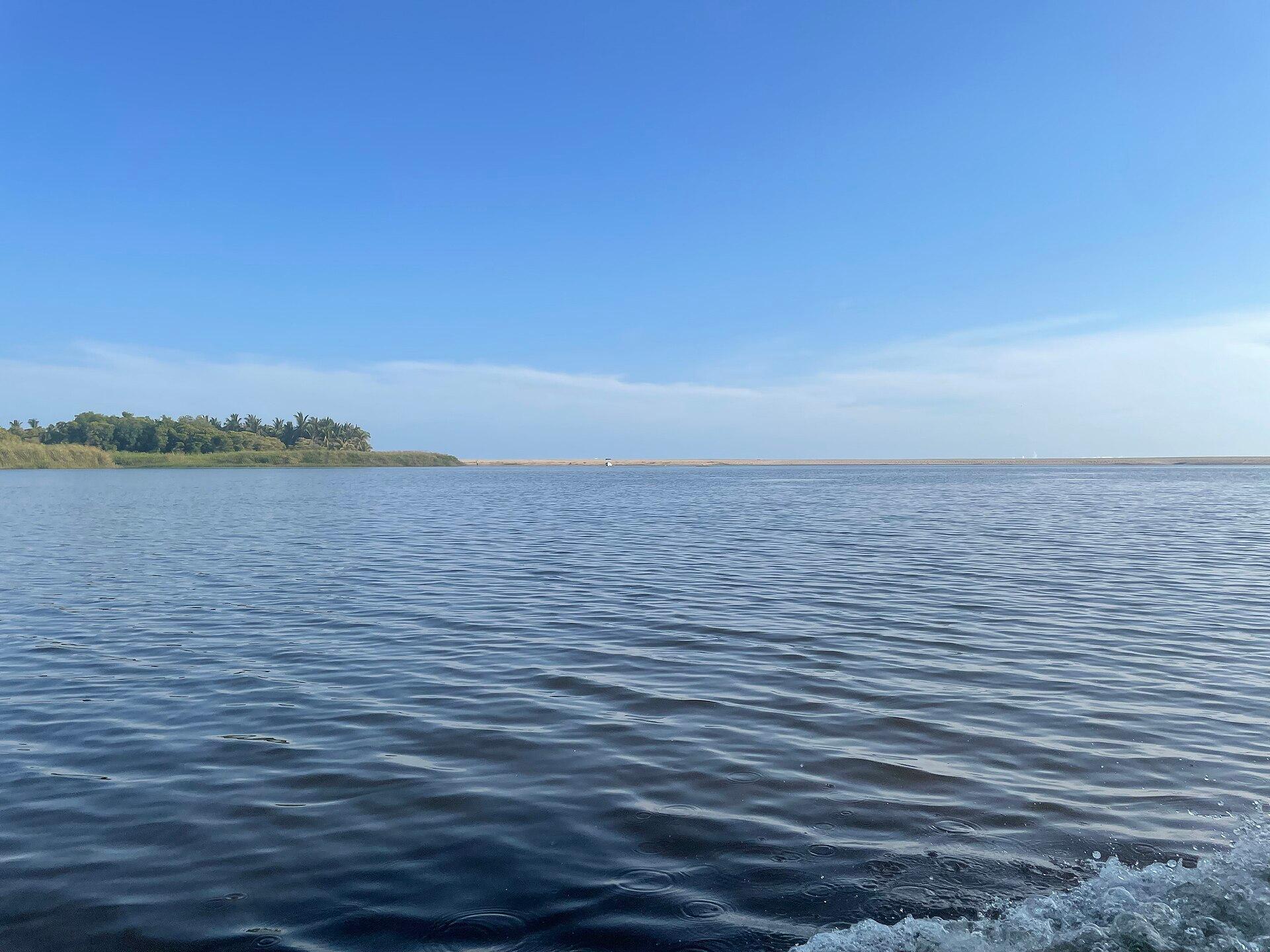 Vista abierta de la Laguna de Manialtepec bajo un cielo azul